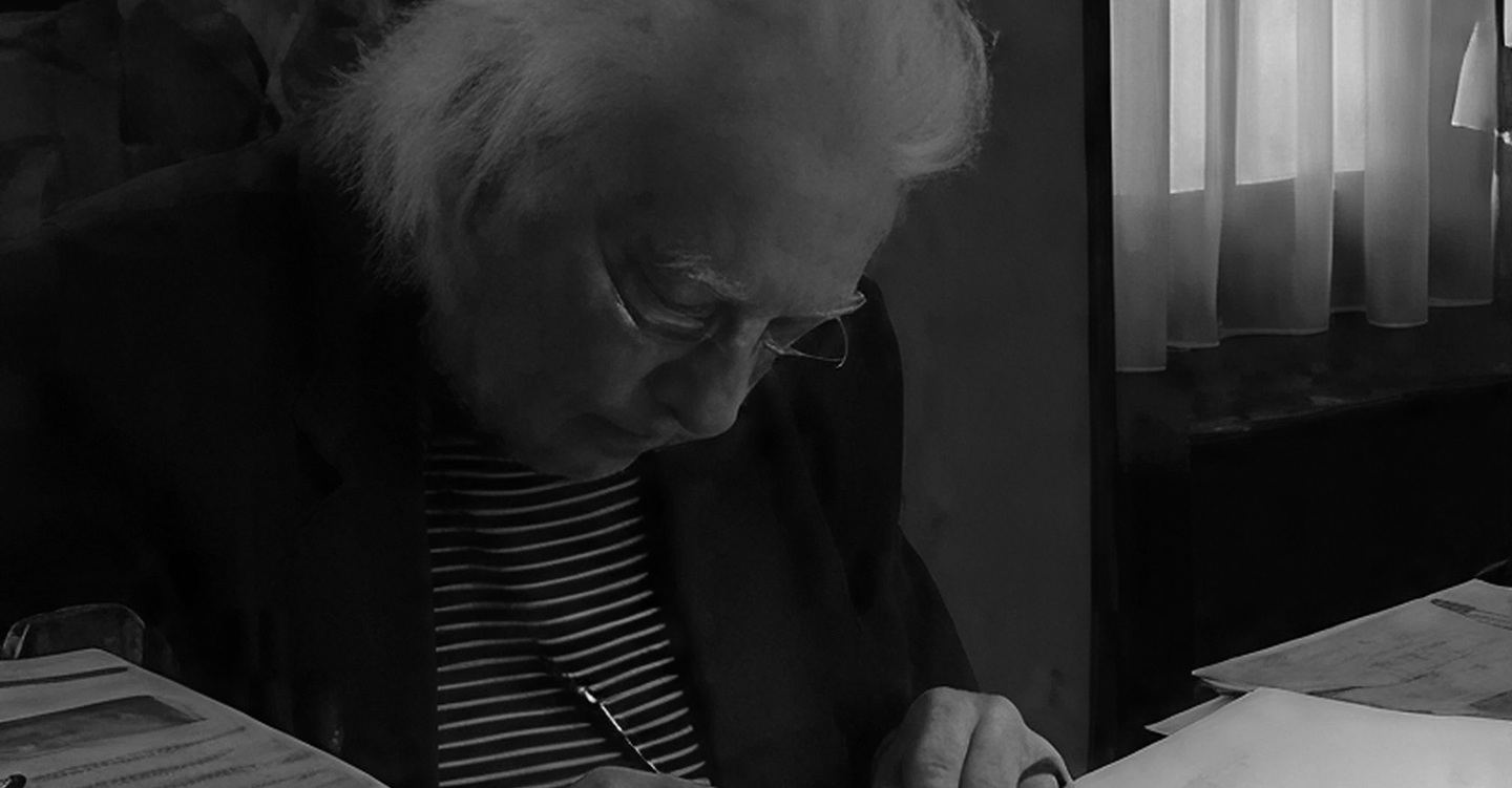 André Guillou penché sur son bureau, en train d'écrire